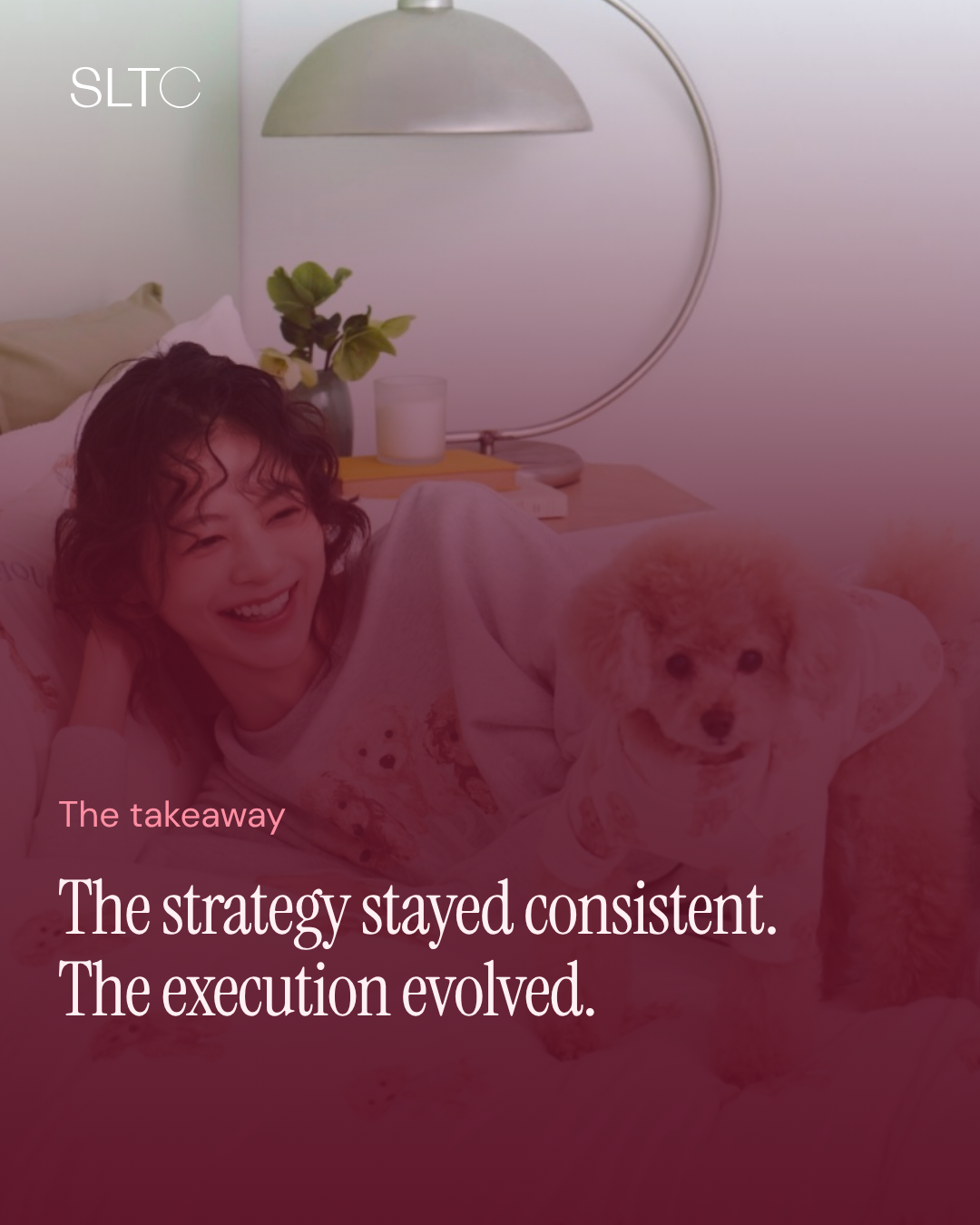 Woman laying down on a bed in her Gelato Pique pajamas with her puppy smiling 
